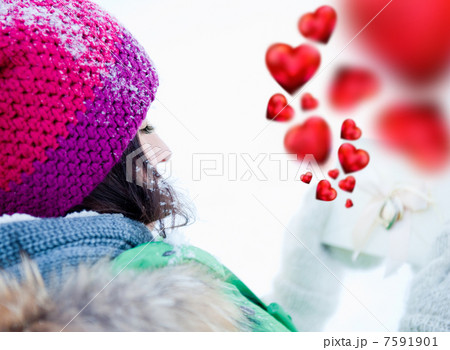 Young lady outdoors happily holding valentine gift and dreaming 7591901