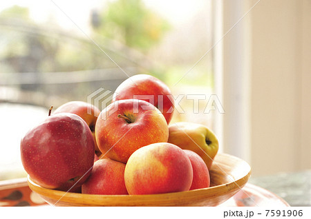 Closeup photo of red apples on wooden plate indoor against wide 7591906