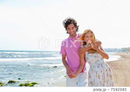 Couple at the beach holding hands and walking. Sunny day, bright 7592085