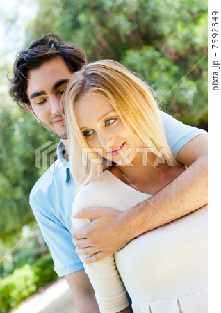 Portrait of love couple embracing outdoor in park looking happy Portrait of love couple embracing outdoor in park looking happy 7592349