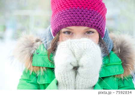 Winter woman in snow looking at camera outside on snowing cold w 7592834