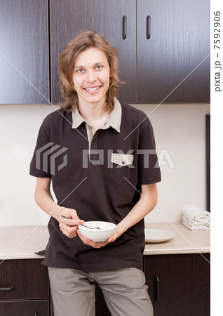 Happy young man after having a breakfast at home 7592906