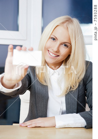 Young businesswoman showing her business card - sitting at her o Young businesswoman showing her business card - sitting at her o 7593288