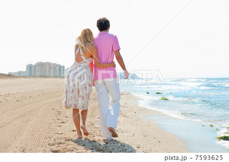 Couple at the beach holding hands and walking. Sunny day, bright Couple at the beach holding hands and walking. Sunny day, bright 7593625