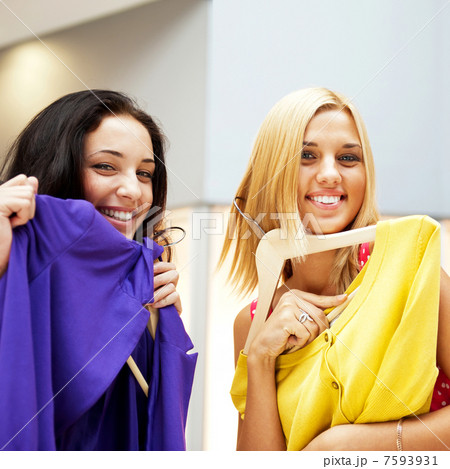 Group of two beautiful shopping women trying on clothes at shopp Group of two beautiful shopping women trying on clothes at shopp 7593931