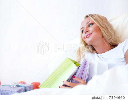 Young happy attractive girl unpack shopping bags in bedroom or h Young happy attractive girl unpack shopping bags in bedroom or h 7594660