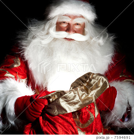 Santa sitting at the Christmas room and looking into the sack Santa sitting at the Christmas room and looking into the sack 7594691