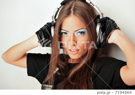 Club style woman with headphones listening to music looking at c 7594869