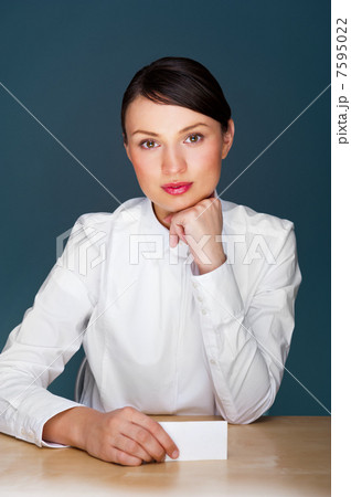 Young businesswoman showing her business card - sitting at her o Young businesswoman showing her business card - sitting at her o 7595022