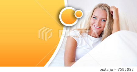 Young blond woman enjoying a sunny morning in bed 7595085