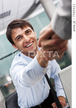 Closeup of business people shaking hands over a deal at office - Closeup of business people shaking hands over a deal at office - 7595421
