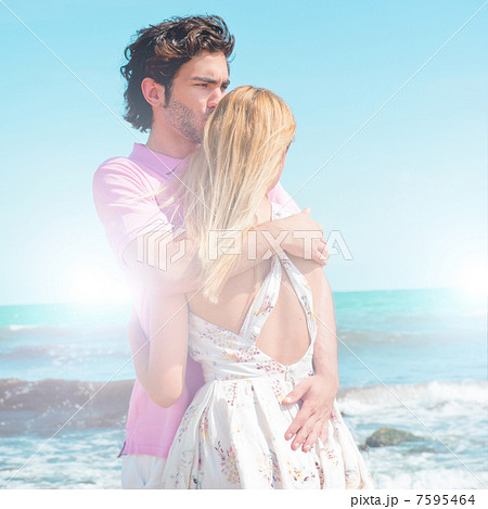Portrait of young couple in love embracing at beach and enjoying 7595464