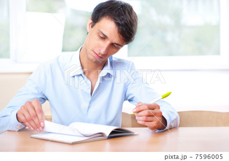 Businessman sitting indoors and writing plan in his diary 7596005