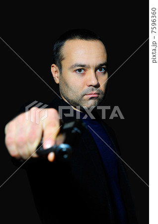 Portrait of a mature man drawing a gun in self defense studio sh 7596360