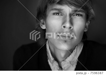 Portrait of young man with smart and wise look. Looking at camer 7596387