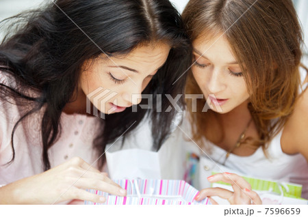 Two excited shopping woman together inside shopping mall laughin Two excited shopping woman together inside shopping mall laughin 7596659