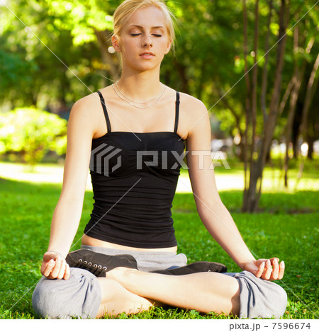 Portrait of young beautiful couple sitting in lotus pose on gree Portrait of young beautiful couple sitting in lotus pose on gree 7596674