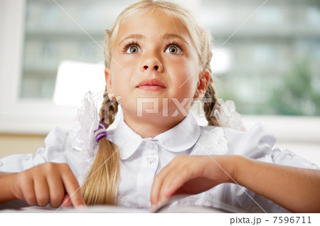 Portrait of a young girl in school at the desk. Portrait of a young girl in school at the desk. 7596711