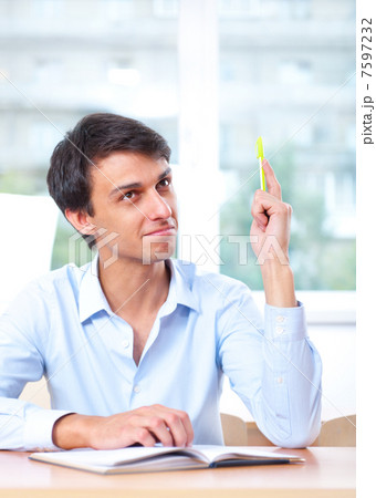 Businessman sitting indoors and writing plan in his diary 7597232