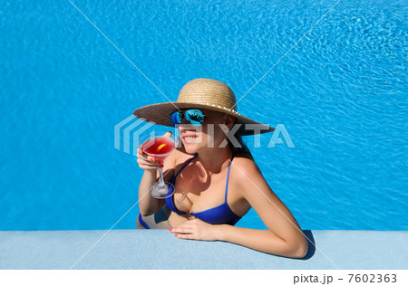 Woman at poolside with cosmopolitan cocktail Woman at poolside with cosmopolitan cocktail 7602363