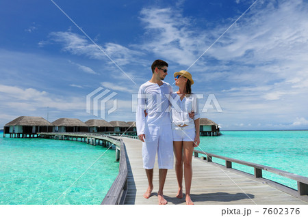 Couple on a beach jetty at Maldives 7602376