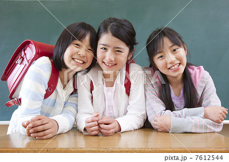 黒板の前で微笑む小学生女子3人 7612544