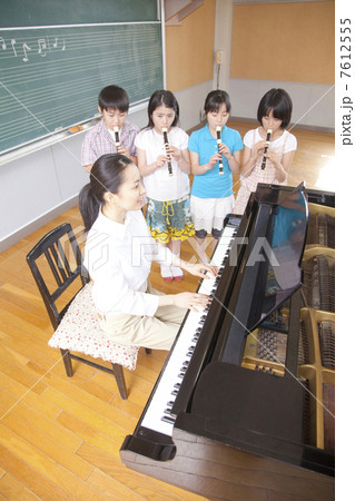 音楽室でリコーダーを吹く小学生4人 7612555