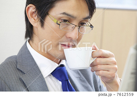 新聞を読みながらコーヒーを飲むビジネスマン 7612559