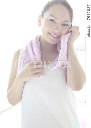 タオルで頬を拭く女性 7612887