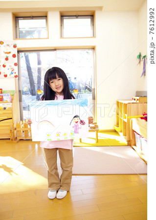 絵を持って微笑む幼稚園女児 7612992