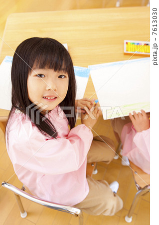 クレヨンを手に持って微笑む幼稚園女児 クレヨンを手に持って微笑む幼稚園女児 7613030
