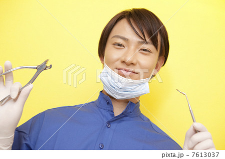 口腔鏡とペンチを持った男性歯科医 7613037