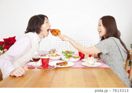 男性にチキンを食べさせてあげる女性 男性にチキンを食べさせてあげる女性 7613313