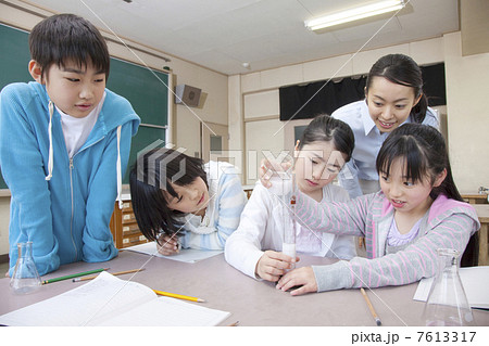 理科の実験をする小学生男女と女性教師 理科の実験をする小学生男女と女性教師 7613317