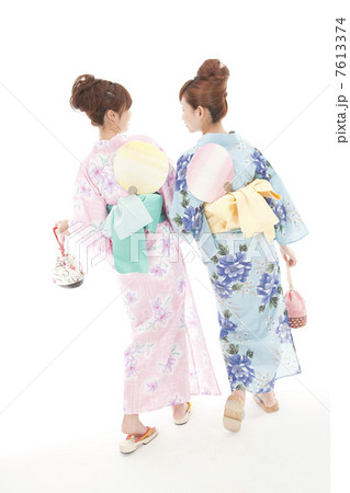 巾着袋を持って歩く浴衣女性2人の後姿 7613374