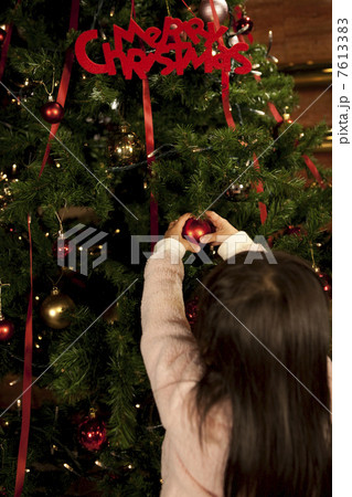 クリスマスツリーの飾りつけをする女の子の後ろ姿 クリスマスツリーの飾りつけをする女の子の後ろ姿 7613383