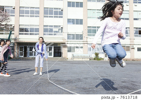 大縄跳びをする小学生と教師 7613718