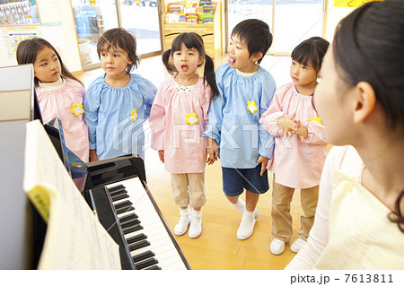 幼稚園教諭のピアノに合わせて歌う幼稚園児 7613811