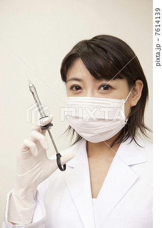 注射器を持つ女性歯科医 7614139
