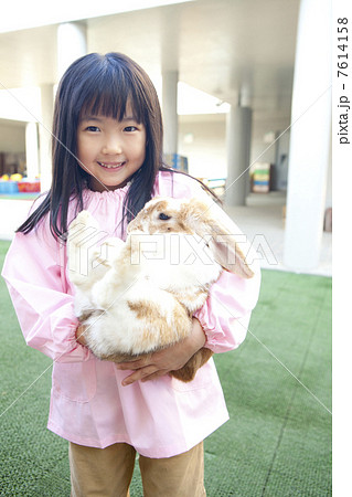 うさぎを抱っこする幼稚園女児 7614158
