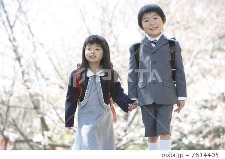 桜の下に立つ小学生男女 7614405