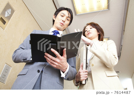 廊下で談笑するビジネスマンとOL 7614487