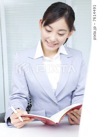 手帳を確認するOL 7614491