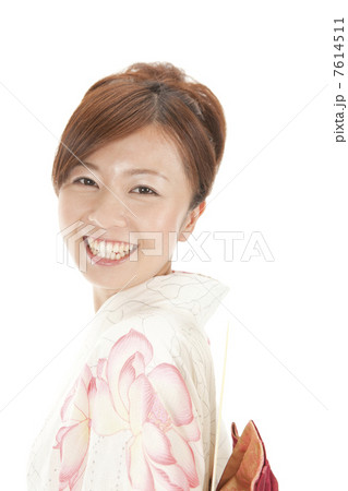 帯に団扇を差して振り返る浴衣女性 7614511