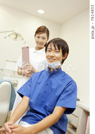 治療台の前で微笑む歯科医と歯科衛生士 7614855