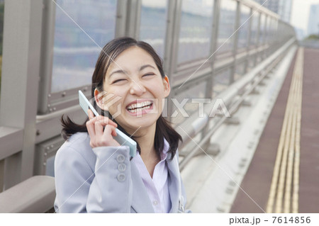 携帯電話で通話するOL 7614856