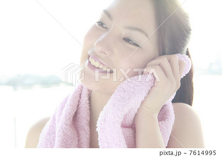 タオルで頬を拭く女性 7614995