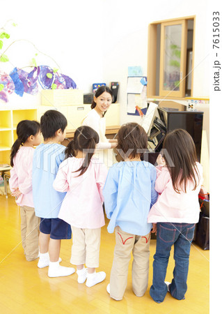 幼稚園教諭のピアノに合わせて歌う幼稚園児 7615033