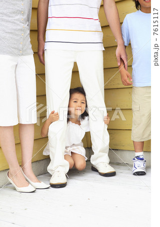 父親の足元に隠れる女の子 7615117