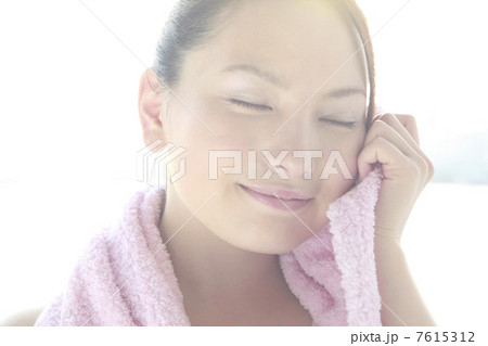 タオルで頬を拭く女性 7615312